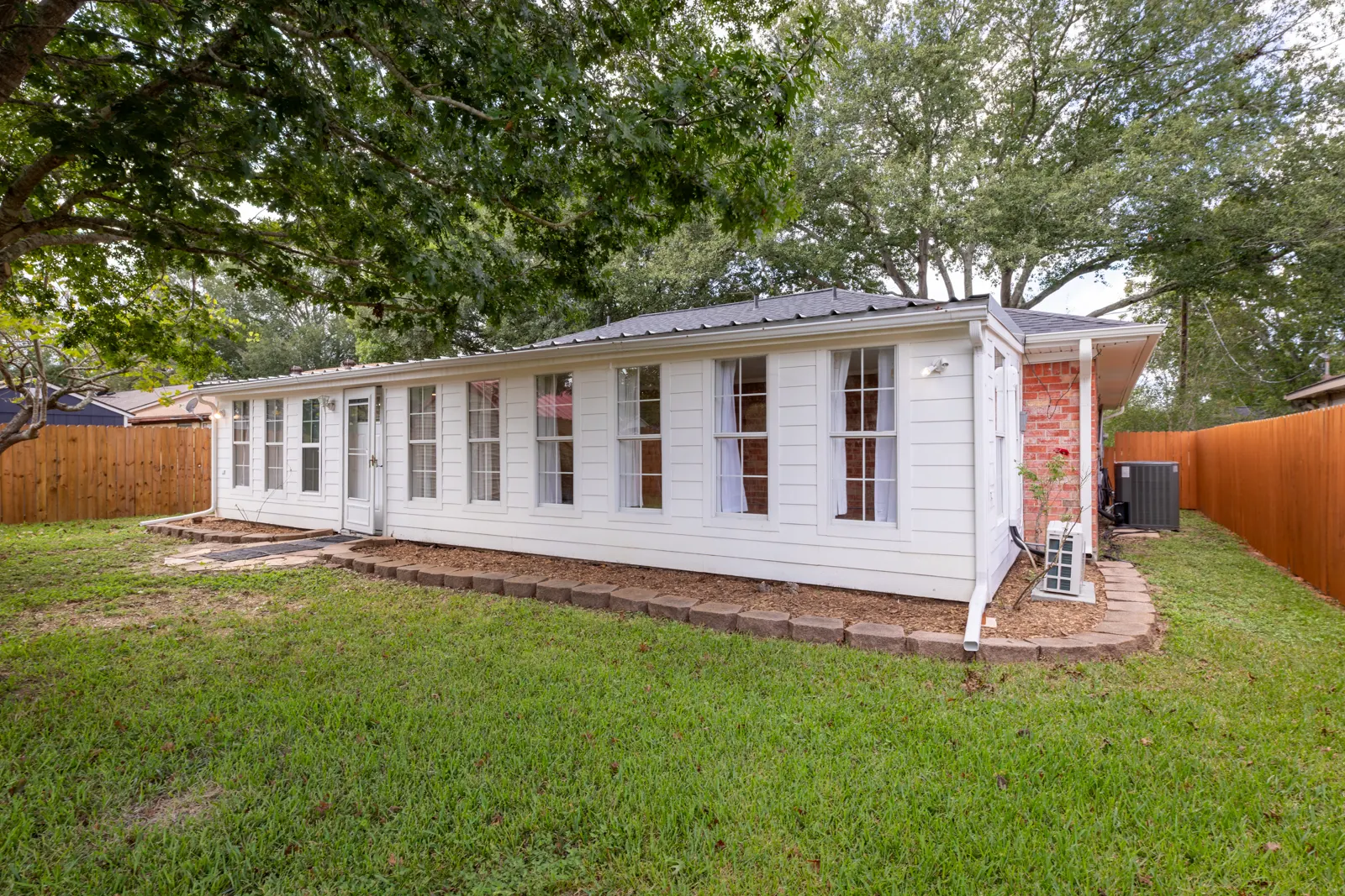Back of the home with a row of family room windows