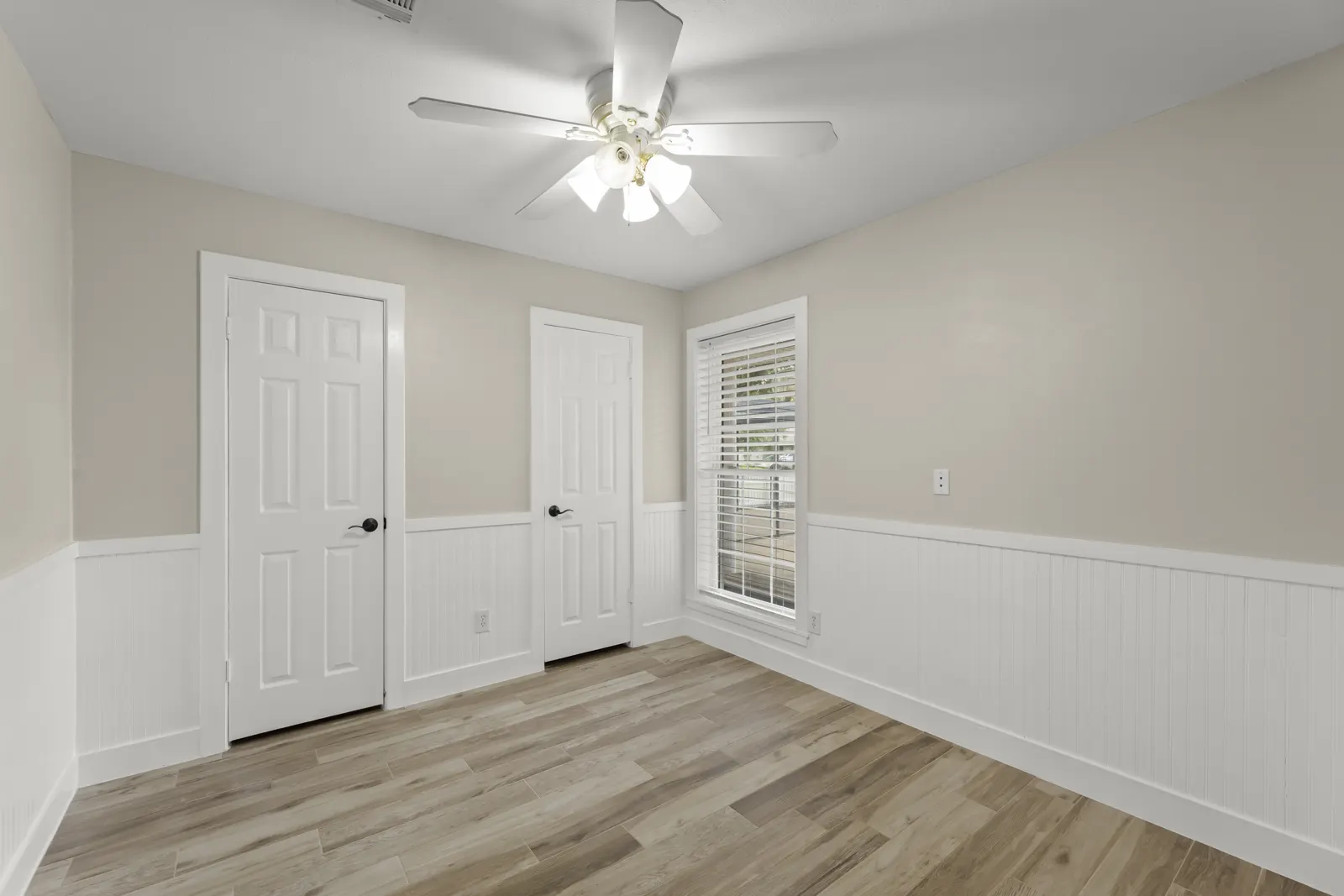 Bedroom with wainscoting and ceiling fan