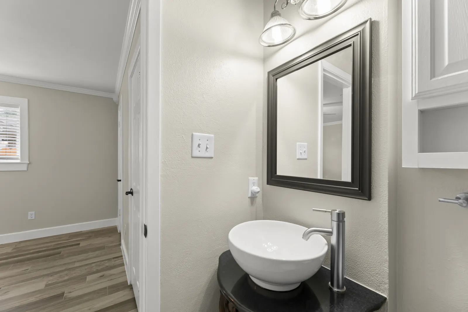 Bathroom with vessel sink and black framed mirror