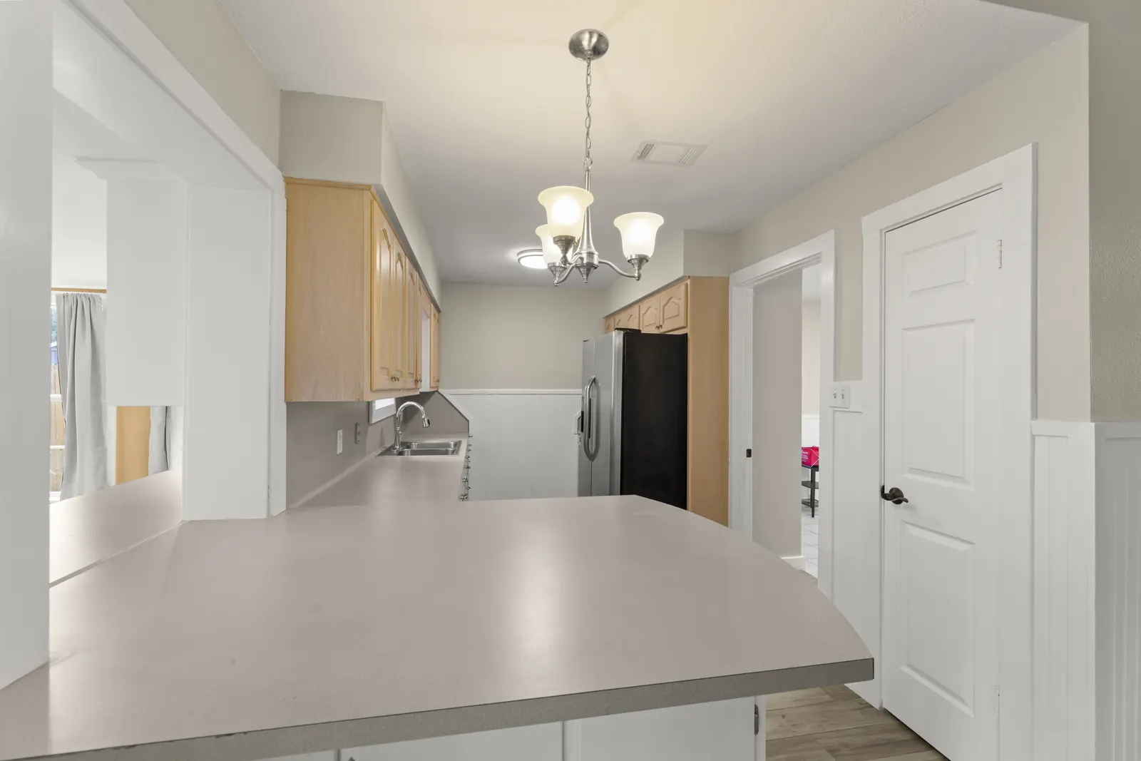 Kitchen with breakfast bar, wood cabinets and pendant light
